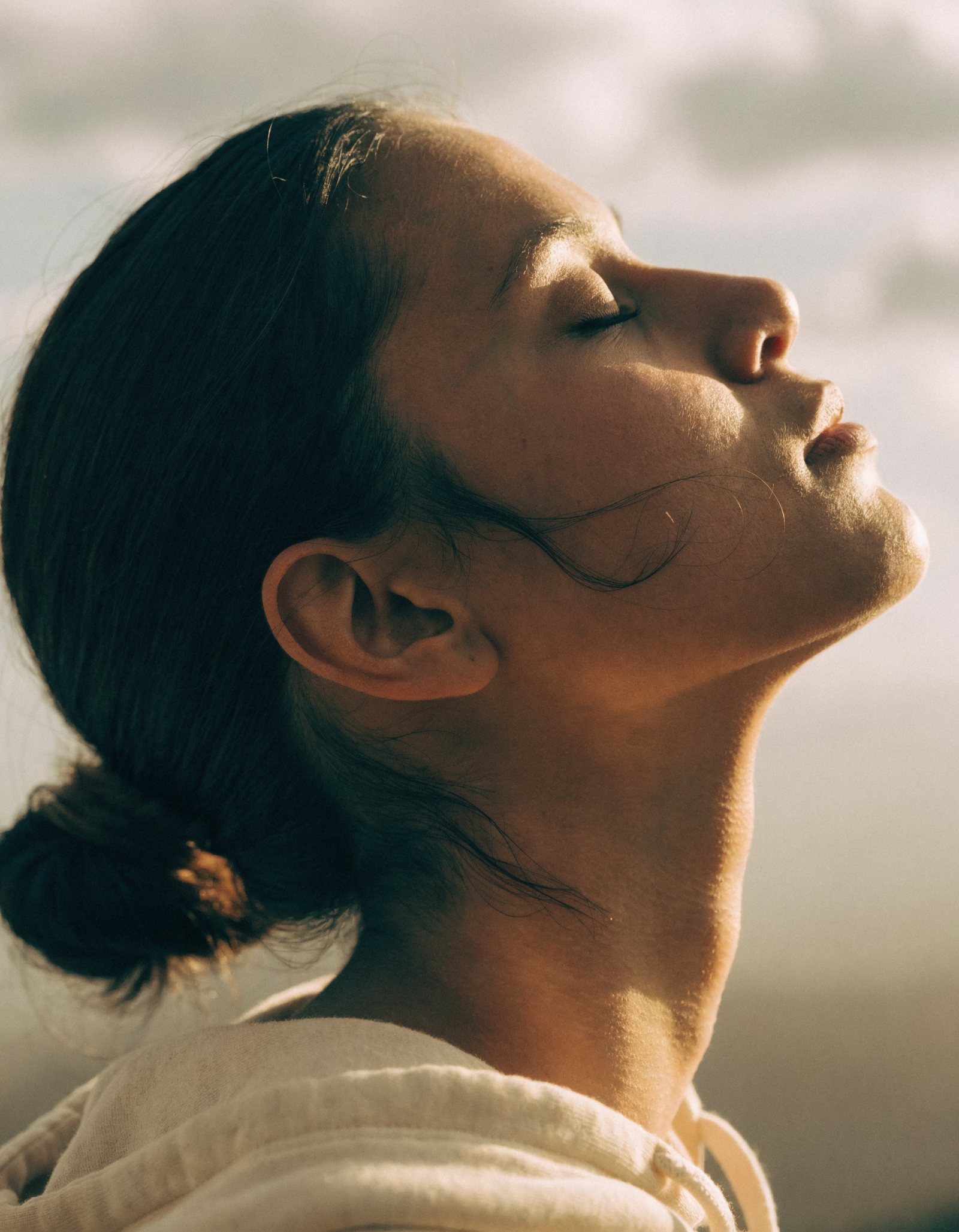 A person with their face turned to the morning sky
