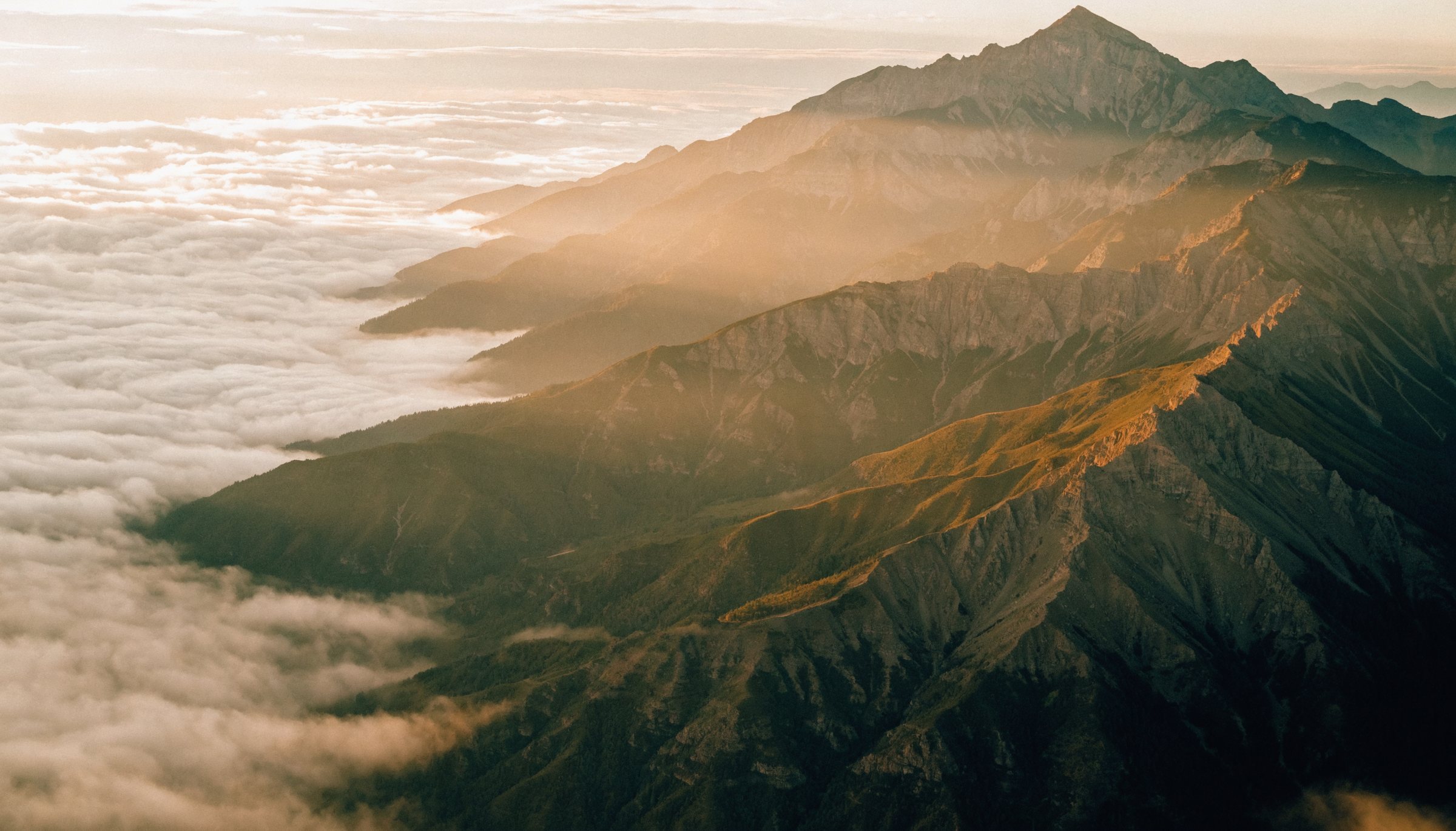 Sunrise over a mountain range above a sea of cloud