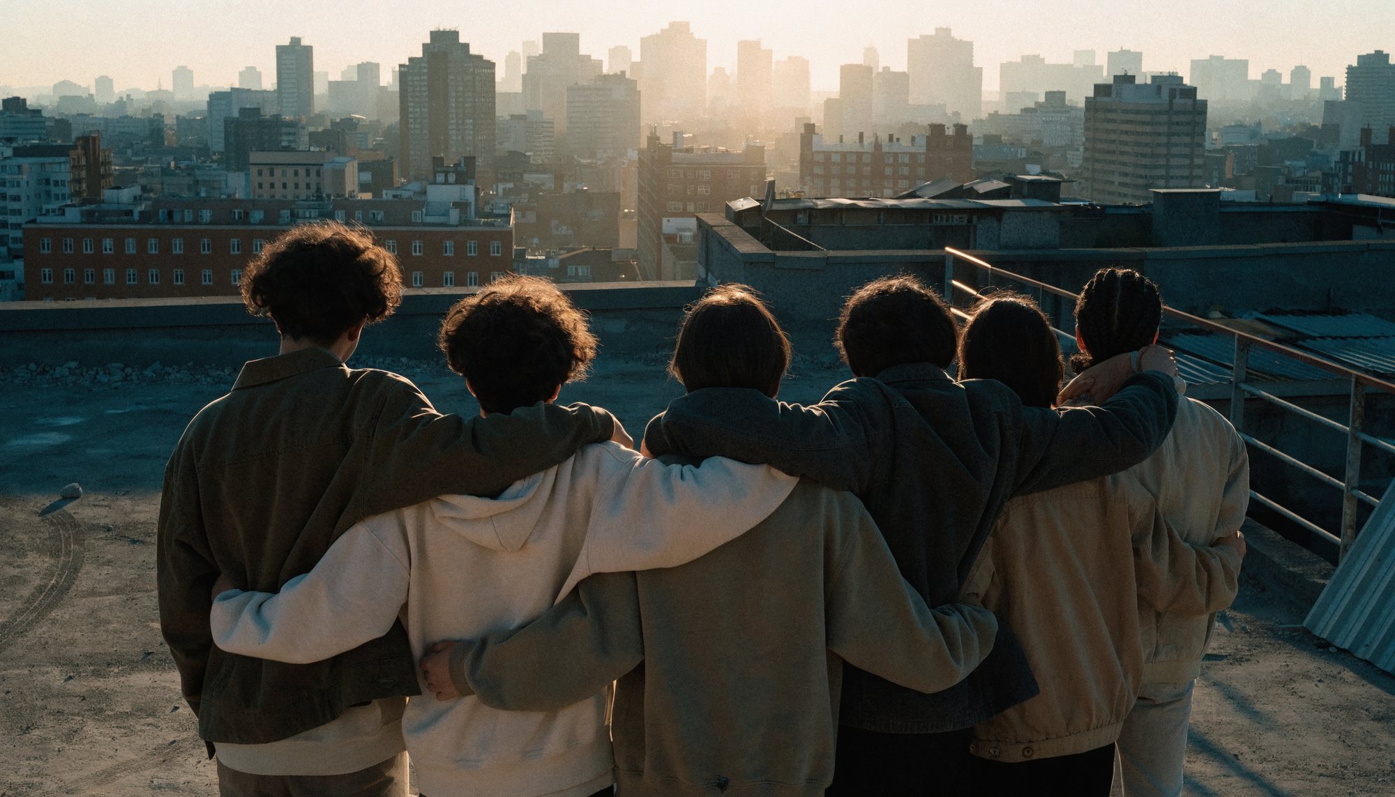 People standing together at dusk with arms linked